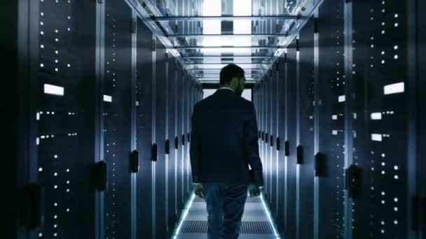 Tecnico del data center che cammina attraverso il corridoio dello scaffale del server Ispezione visiva degli armadi del server di lavoro
. - Filmati, video