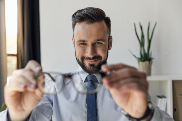 businessman holding eyeglasses - Fotografie, Obrázek