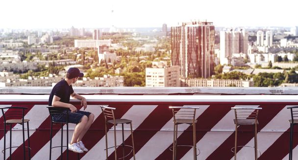 Young man on the roof of a tall building - Photo, Image