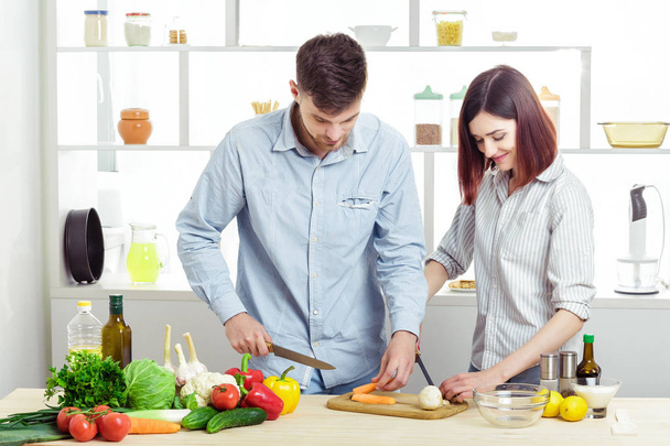 Любящие счастливые пары готовят здоровый салат из свежих овощей на кухне
 - Фото, изображение