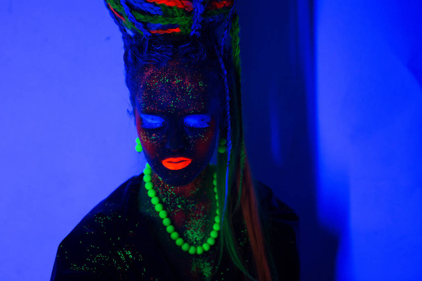 luminous portrait of a girl in the UV rays on dark background - Fotografie, Obrázek