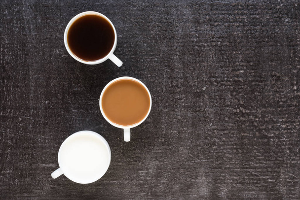 Three cups with coffee and milk on black background - Φωτογραφία, εικόνα