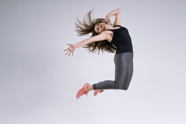 Girl in jump on a gray background - Zdjęcie, obraz