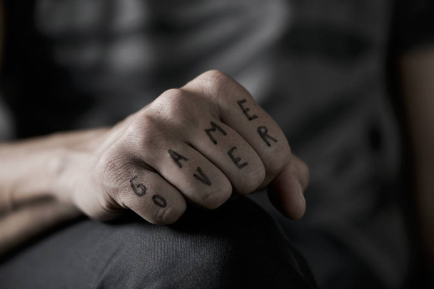 text game over in the knuckles of a young man - Photo, Image