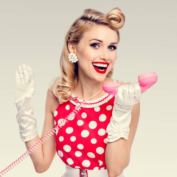 smiling woman with phone, dressed in pin-up style dress - Фото, изображение