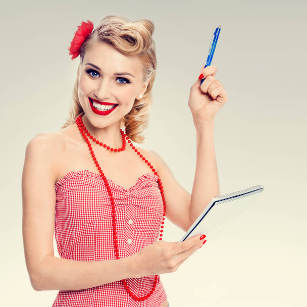 smiling woman with notepad, in pin-up style clothing - Foto, afbeelding