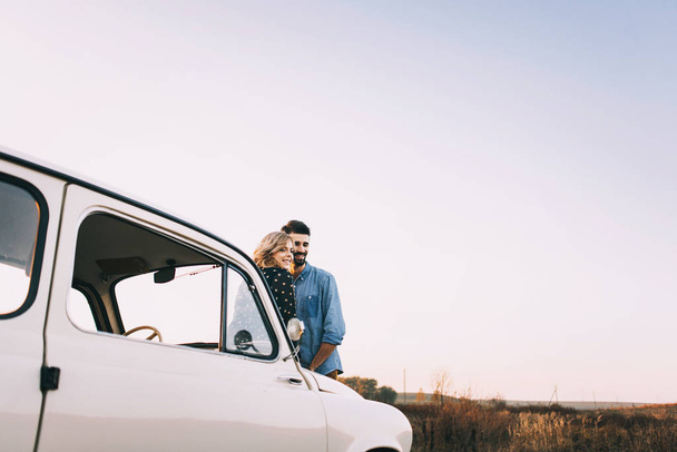 Couple by retro white car in field - Photo, Image