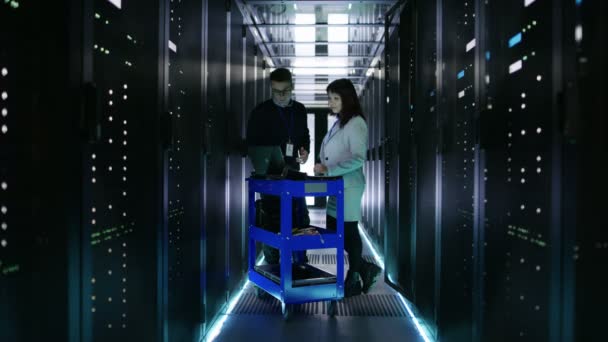 Valkoihoinen mies ja aasialainen nainen palvelin insinöörit työskentelevät Crash Cart Laptop Big Data Center täynnä Rack Servers
. - Materiaali, video