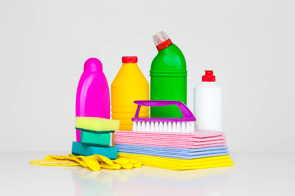 Асортимент побутових прибиральників. Мийні засоби, хімічні пляшки, чистячі губки та рукавички. на білому тлі
 - Фото, зображення