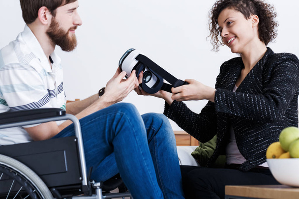 Therapist giving patient VR goggles - Foto, afbeelding