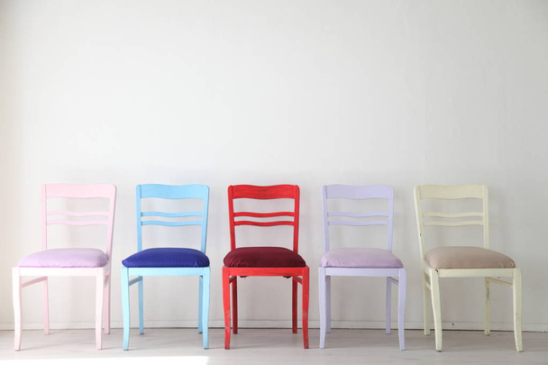 Quarto branco com cadeiras coloridas azul amarelo vermelho azul roxo
 - Foto, Imagem