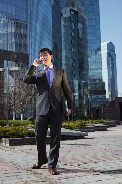 Young businessman standing and talking on mobile phone - Photo, image