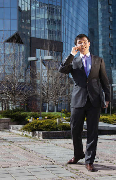 mladý podnikatel, stojí a mluví na mobilním telefonu - Fotografie, Obrázek