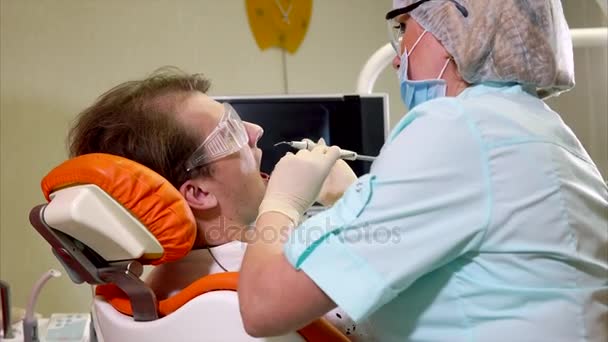 Dentista mulher fazendo procedimento de tratamento dentário. Assistente ajudando-a
 - Filmagem, Vídeo