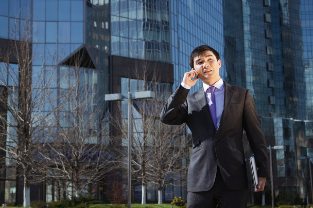 Young businessman talking on mobile phone. - 写真・画像