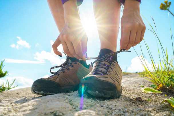 Hiking shoes - woman tying shoe laces - 写真・画像