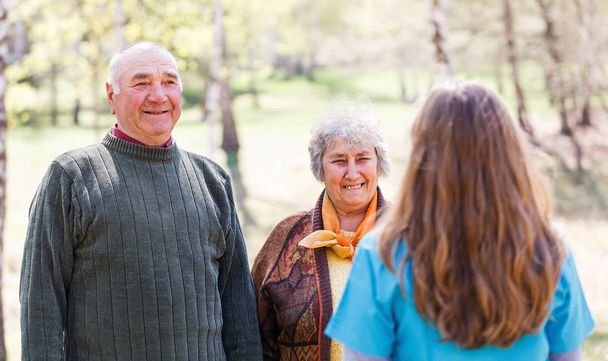 Yaşlı çift ve genç caregiver - Fotoğraf, Görsel