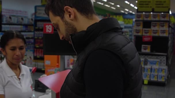 Jonge klant in een punt van de kassa in de supermarkt - Video