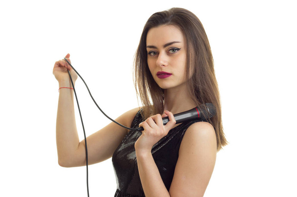 sexy joven sosteniendo un micrófono de karaoke aislado sobre un fondo blanco
 - Foto, Imagen