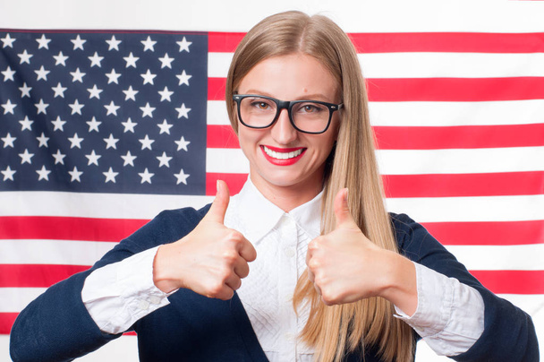 4th of July. Smiling young woman on United States flag background.  - Photo, Image