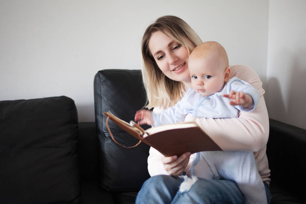 Young mother and her child reading a book, the concept of early development, indoor - Foto, Imagem
