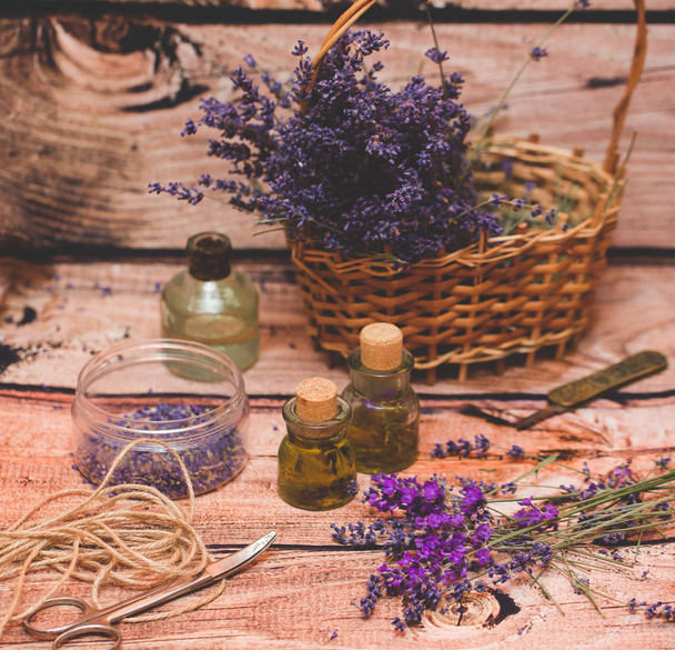 Lavender το πετρέλαιο με φρέσκα λουλούδια σε φόντο ξύλινη. - Φωτογραφία, εικόνα