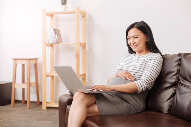 Smiling pregnant woman using a laptop - Photo, Image