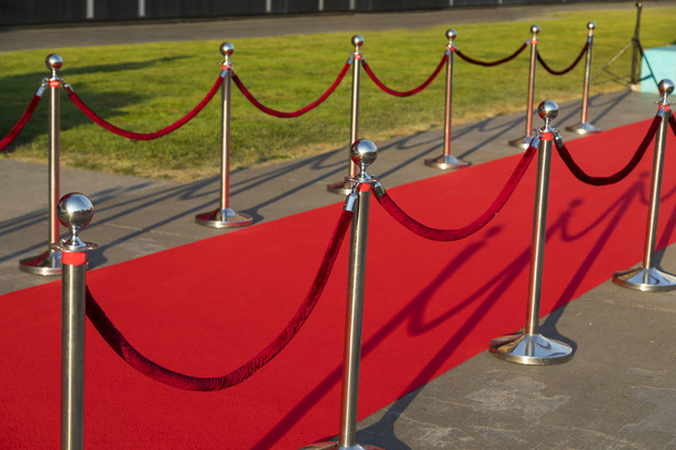 Alfombra roja larga entre las barreras de cuerda en la entrada VIP
. - Foto, imagen