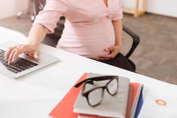 Pregnant woman using laptop in the office - Fotó, kép