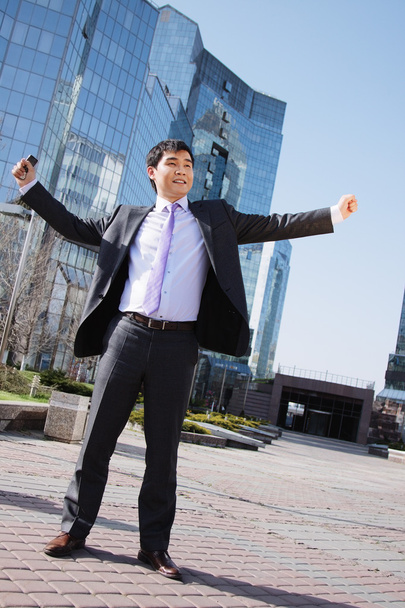 Happy asian businessman standing outside with arms outstretched - Foto, imagen