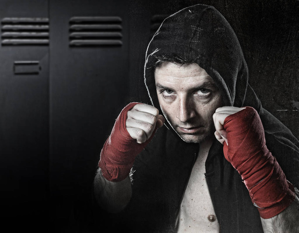 homem em boxe hoodie jumper com capuz na cabeça vestindo mão e pulso embrulhado pronto para a luta
 - Foto, Imagem