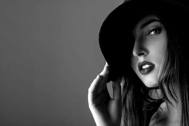 Black and white portrait of beautiful sexy woman in black hat - Фото, зображення
