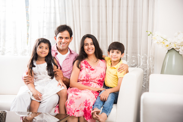 Portrait franc de la famille indienne intelligente de quatre personnes assis sur le canapé. Photo de famille indienne ou asiatique. Concentration sélective
 - Photo, image