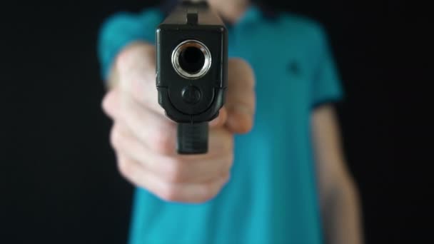 mladý muž posílá černou zbraň na kameru - Záběry, video