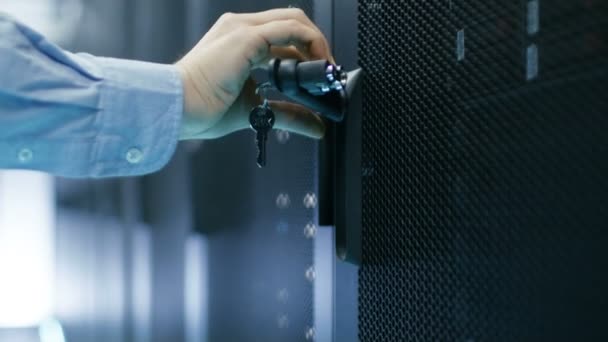 In datacenter Man sluit Server Rack kabinetsdeuren en bladeren.  - Video