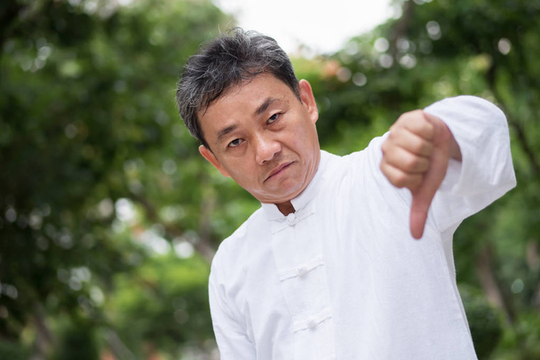 asiatico kung fu anziano uomo mostrando pollice giù mano gesto
 - Foto, immagini