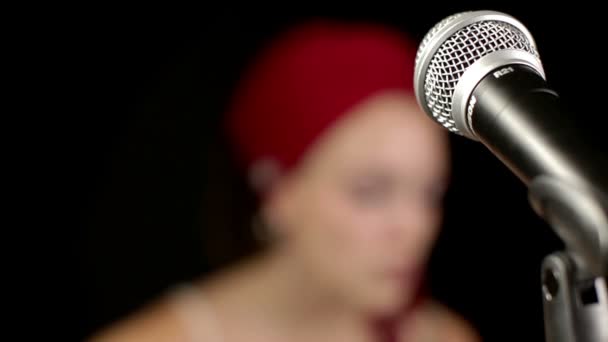 krásná zpěvačka s červeným ovinout kolem její hlavy - Záběry, video