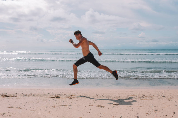 athletic man running on beach - Foto, Imagem