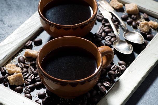 две чашки черного кофе на доске, крупным планом
 - Фото, изображение