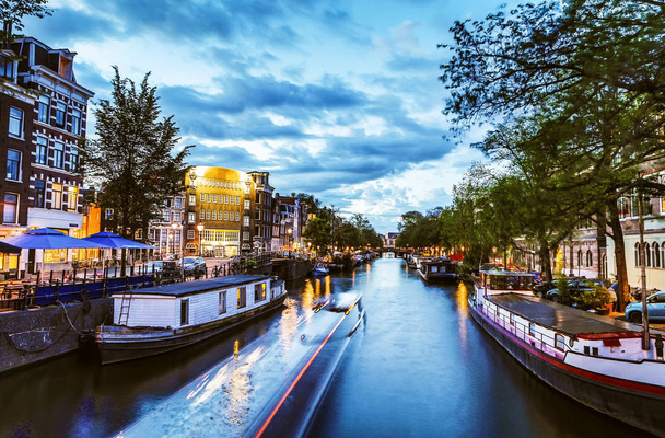 Les canaux et les remblais les plus célèbres de la ville d'Amsterdam la nuit. Vue générale du paysage urbain et de l'architecture traditionnelle néerlandaise
. - Photo, image
