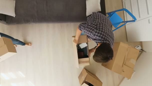 View from the top on young family moving in new house and unpacking boxes - Footage, Video