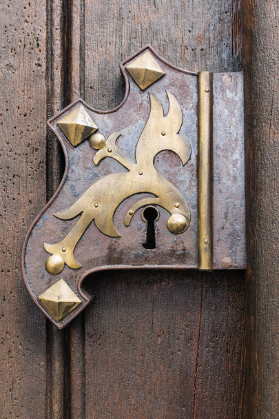 Большая деревянная дверь с деревянными элементами. Декоративная дверь с фурнитурой
. - Фото, изображение