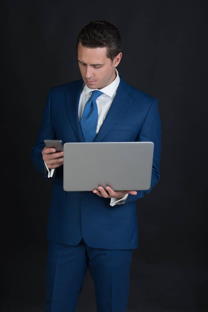 businessman using mobile phone while working on laptop - Foto, imagen