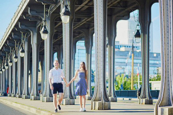 Couple walking along Bir-Hakeim bridge in Paris, France - Fotoğraf, Görsel