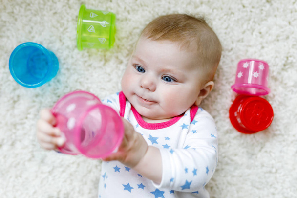Bonito bebê recém-nascido adorável brincando com brinquedo chocalho educacional colorido
 - Foto, Imagem