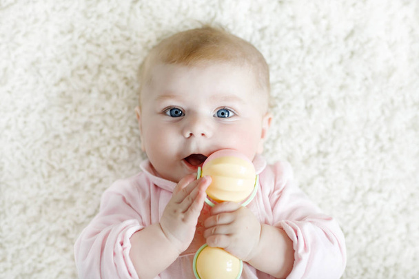 Nettes Baby-Mädchen spielt mit bunten Pastell Vintage Rassel Spielzeug - Foto, Bild