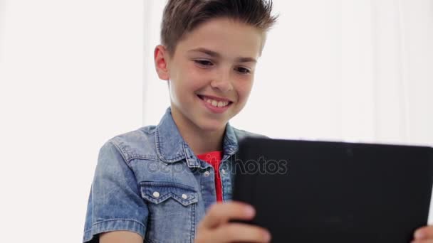 usměvavý chlapec s počítačem tablet pc doma - Záběry, video