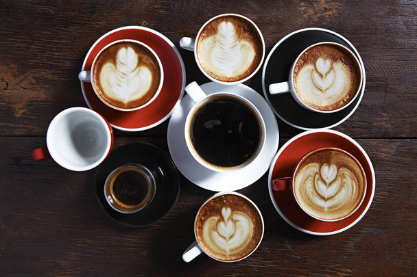 木製の背景、平面図上にコーヒーの多くのカップ。アイデア通信企業コンセプト - 写真・画像