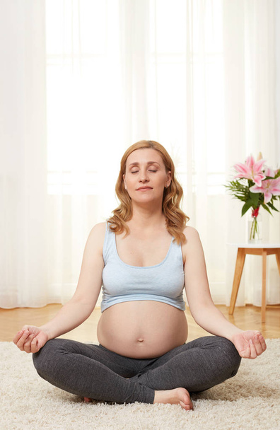 Pregnant woman meditating - Фото, изображение