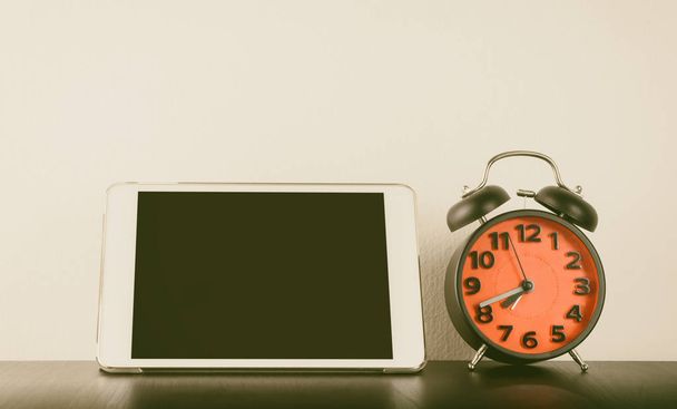 Relógio despertador com tela Tablet em branco na mesa de escritório
 - Foto, Imagem